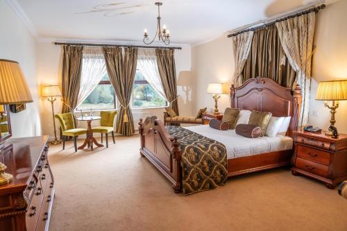 圭多尔An Chúirt Hotel, Gweedore, Donegal的卧室配有一张床和一张桌子及椅子