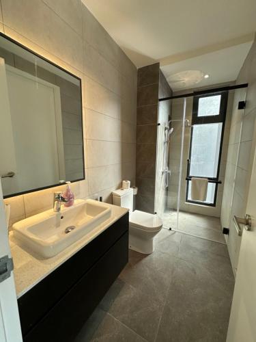 吉隆坡AXON Suites Bukit Bintang By Sky Pool的一间带水槽、卫生间和镜子的浴室
