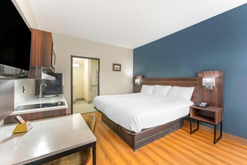 拉瓦莱Suburban Studios LaVale - Cumberland的酒店客房设有一张大床和一台电视机。