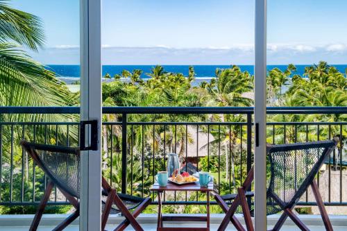 克罗托格奥瑞格斐济海滩度假酒店的阳台配有一张桌子和两把椅子,享有海景