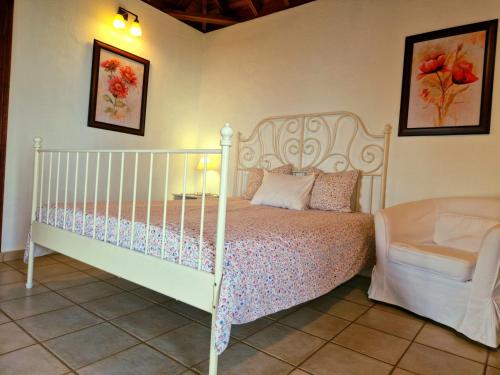 下布雷尼亚Casita Canaria con Vista的卧室配有白色的床和椅子