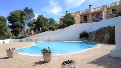 桑帕克Apartamento en el campo de golf Son Parc, Menorca的大楼前的游泳池