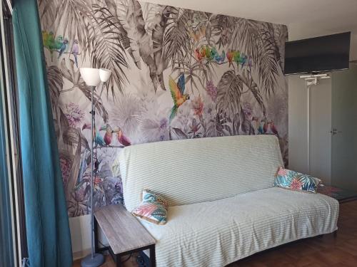 阿格德角Appartement centre port Cap d'Agde的客厅配有白色沙发,拥有热带壁纸