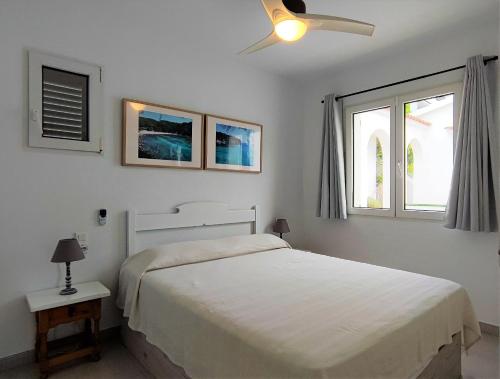 桑帕克Apartamento en el campo de golf Son Parc, Menorca的一间白色卧室,配有床和2个窗户