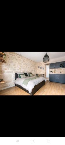 巴黎IMHOST - Amazing architect studio Père Lachaise的一间卧室设有一张大床和石墙