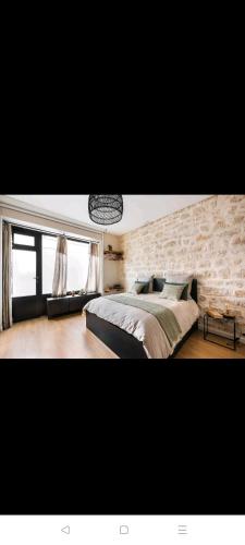 巴黎IMHOST - Amazing architect studio Père Lachaise的一间卧室设有一张大床和石墙