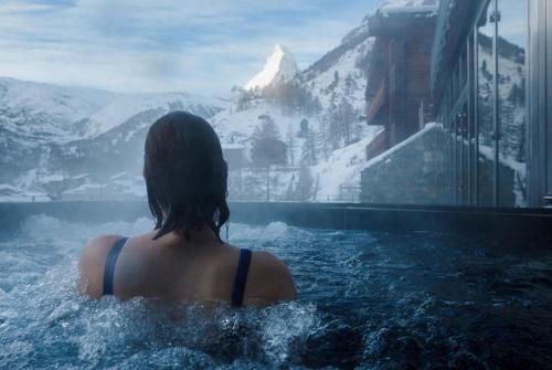 采尔马特奥莫尼亚酒店的一位女性,在游泳池里,欣赏山景