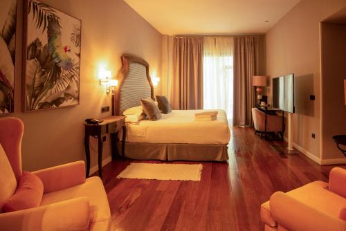乌贝达Hotel Don Juan Boutique的酒店客房,配有床和沙发