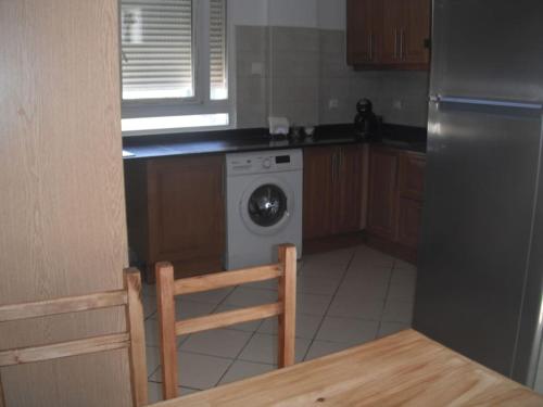 奥兰Bien situé T4 à Oran的厨房配有洗衣机和桌子