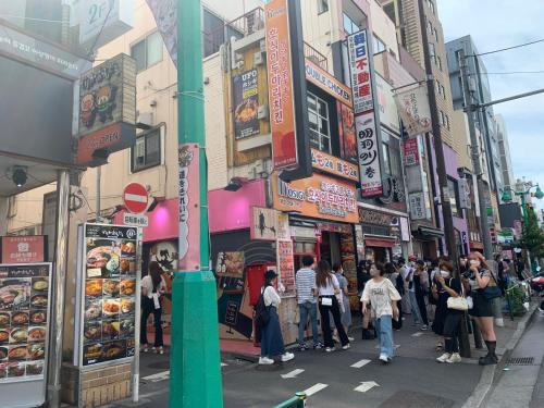东京City Hotel Dolphin的一群人沿着繁忙的城市街道走着