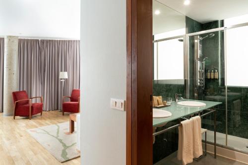 索里亚索里亚酒店的一间带两个盥洗盆和红色椅子的浴室