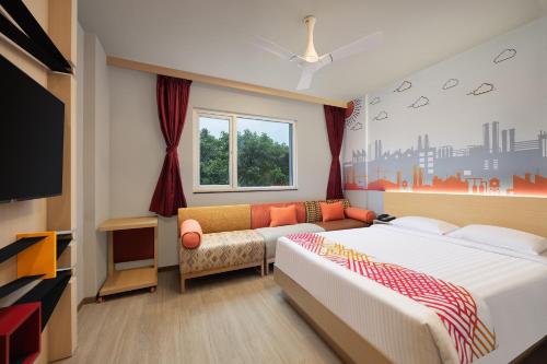 诺伊达Ginger Noida 63的一间卧室配有一张床、一张沙发和一台电视。