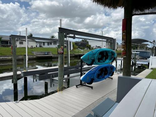 珊瑚角Heated pool, Family Fun, Tiki Bar, kayak, 3bd 2ba的两个皮艇坐在码头旁的码头上