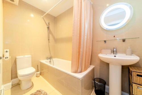 伦敦Comfy 2 bed Apt with Private Garden,Battersea Central LDN的浴室配有卫生间、盥洗盆和浴缸。
