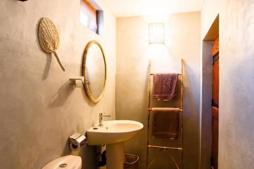 波图维勒PomPon的一间带水槽、镜子和卫生间的浴室