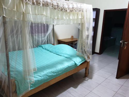 姆巴拉拉3-Bedroom Mbarara Apartment with Optional Farm Tour的一张带天蓬的床