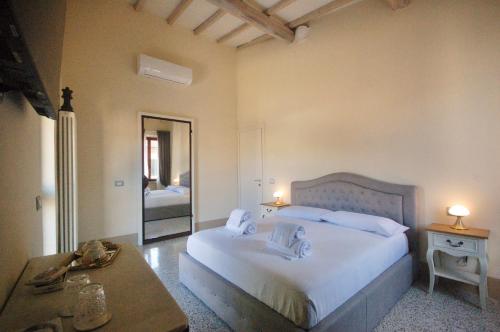 比博纳Residenza d'Epoca CAVALIERE的卧室配有一张白色的大床和一张桌子