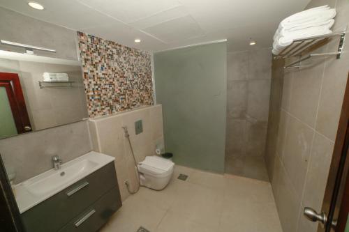 亚喀巴亚福克酒店的浴室配有卫生间、盥洗盆和淋浴。
