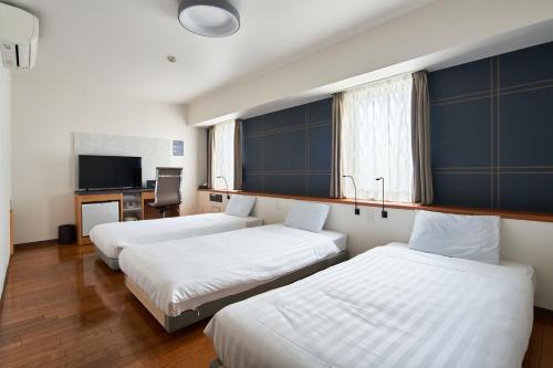东京TOKIO's HOTEL的酒店客房设有三张床和电视。