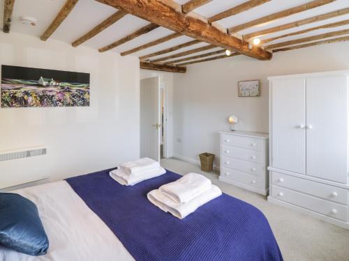 珀肖尔Chapel Cottage的一间卧室配有一张床,上面有两条毛巾