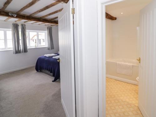 珀肖尔Chapel Cottage的卧室配有床和浴缸