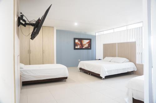 巴兰基亚Apartaestudios lagos的一间卧室设有两张床和蓝色的墙壁
