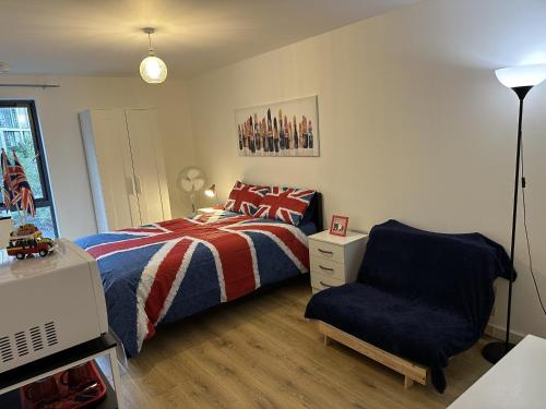 伦敦Modern, Large Independent Room with En-suite Bathroom in Private Owned Apartment的一间卧室配有一张床和一把椅子