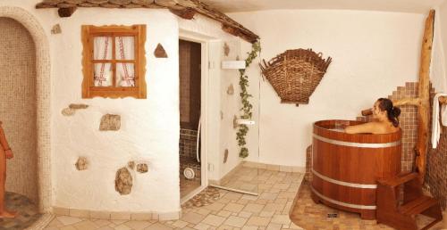 瓦雷纳Berghotel Jochgrimm - Your Dolomites Home的站在一个房间里浴缸里的女人