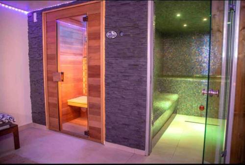 锡富尔勒普拉日Love room - Spa balnéo - Hammam sauna -Emmy Élégance的一间房间里带玻璃门的淋浴