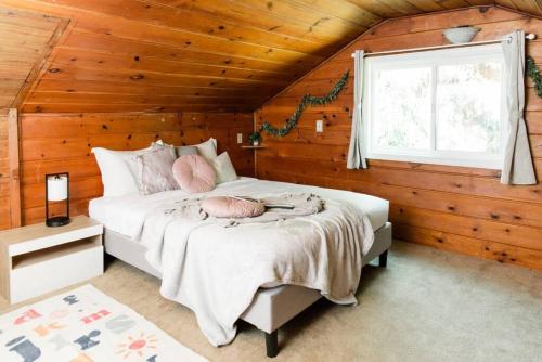 柯克兰Lovely wooden home in urban walking to beach park的木制客房内的一间卧室,配有一张床