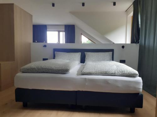 卡尔达罗san Antonia B&B Neu Eröffnung Sommer 2024的卧室配有蓝色和白色的床和2个枕头