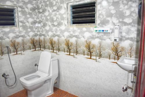 Koppaserene valley koppa hilltop homestay的浴室设有卫生间,墙上有雪景。