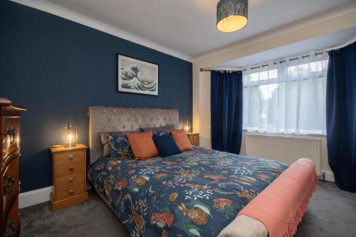 伯恩茅斯Cosy home from home的一间卧室配有一张蓝色墙壁的床和一扇窗户