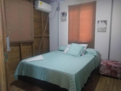 内科克利Sen apto de Madera的一间卧室配有一张带蓝色床单和窗户的床。