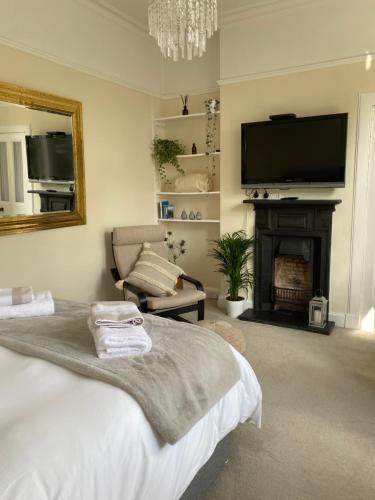 爱丁堡Tranquil Haven Murrayfield的一间卧室配有一张床、一个壁炉和一台电视。