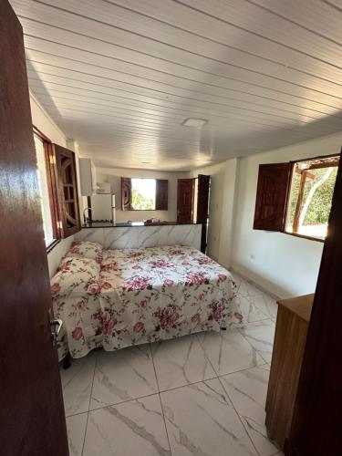 卡博迪圣阿戈斯蒂尼奥Flat Recanto da Natureza的一间卧室配有一张带花卉床罩的床