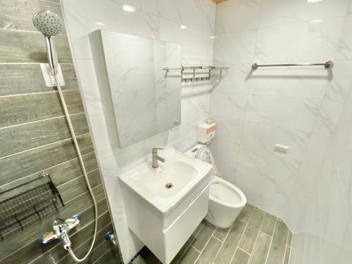 Ch'ing-tao-ts'un康莊背包旅宿 上下舖背包床位4人&6人房&雙人床房-14人包棟-預訂請來電確認的白色的浴室设有水槽和卫生间。