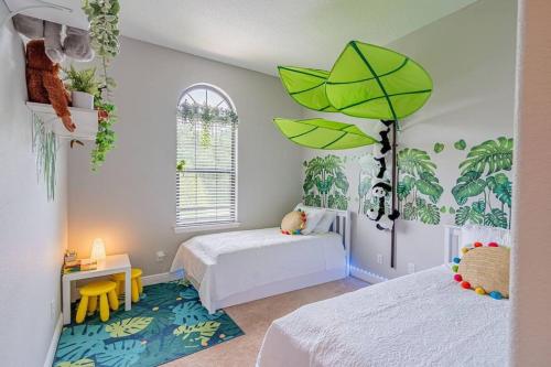 基西米3BD Townhouse , Themed , 10 min to Disney , Gated的一间卧室配有两张床和一把绿色雨伞