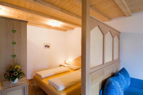马莱斯韦诺斯塔Sonnenheimhof的一间卧室配有两张床和蓝色的沙发