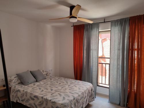 穆尔西亚Apartamentos las flores的一间卧室配有一张床和吊扇