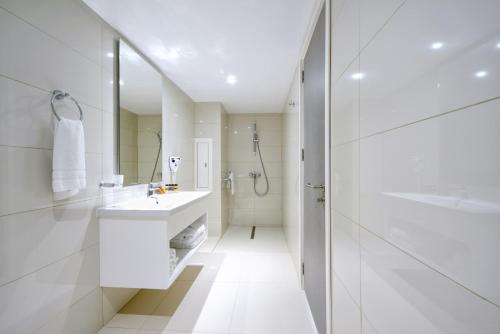 阿依纳帕河石酒店 的白色的浴室设有水槽和淋浴。