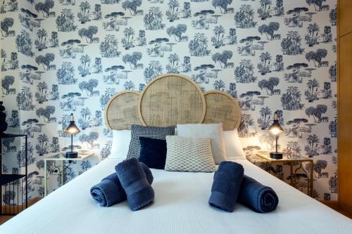 布尔戈斯La Quinta Esencia by Unique Rooms的一间卧室配有一张带蓝色枕头的床