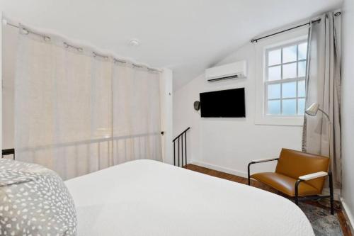 查尔斯顿Exclusive Open Loft in Downtown Charleston的白色卧室配有床和椅子