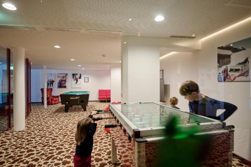 莱赫阿尔贝格奥地利酒店的两个男孩在带台球桌的房间里打台球