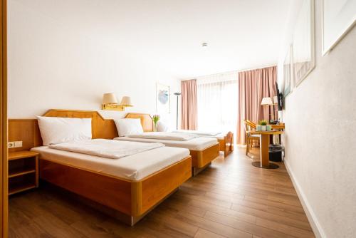 斯图加特CityHotel Feuerbach的酒店客房设有三张床和窗户。