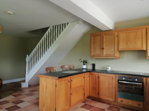 科克Radharc Na Greine的一间带木制橱柜和楼梯的厨房