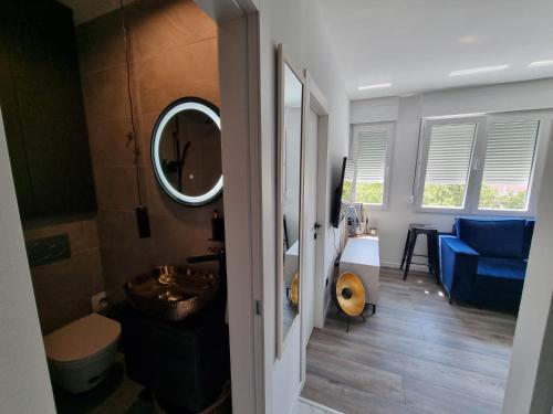 斯普利特LUX BRAND NEW APARTMAN MARIKELA的一间带水槽和镜子的浴室以及一张蓝色的沙发