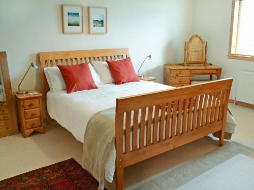 阿克格里尔Fairfield的一间卧室配有一张带红色枕头的木床。