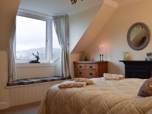 卡伦德Ben Ledi View的一间卧室设有一张大床和一个窗户。