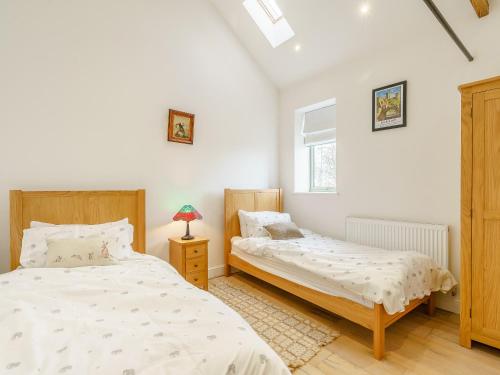Trimdon GrangeAbigails Cottage的一间卧室设有两张床和窗户。